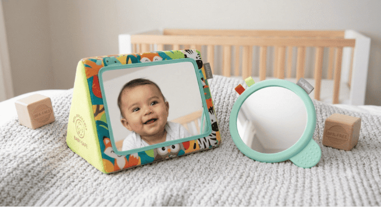 A colorful standing baby-safe floor mirror showing a baby's reflection next to a handheld mint green mirror. Sensory Play for 3-Month-Olds