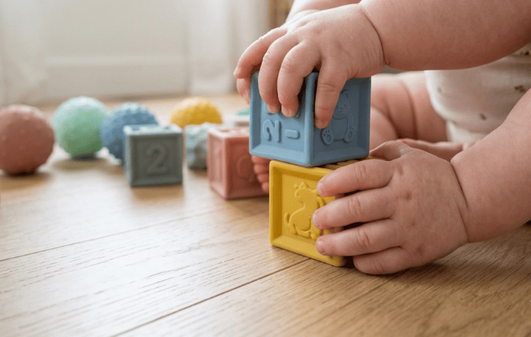 Baby exploring soft textured silicone blocks