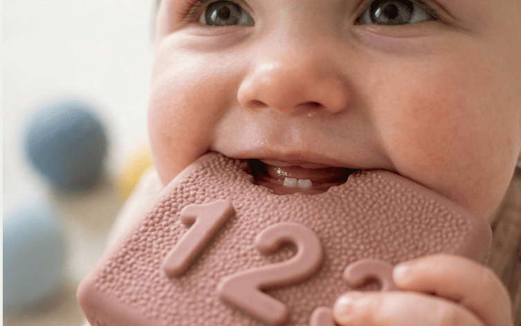 Baby chewing a soft silicone sensory block