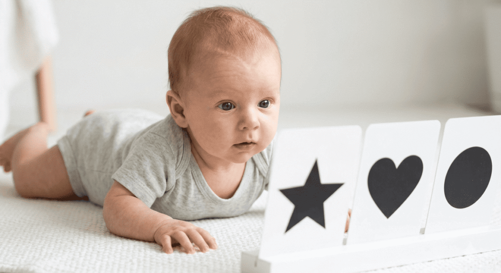 Newborn baby looking at black and white high-contrast cards